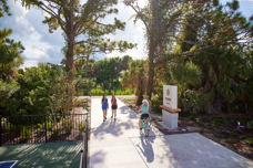 entrance to Legacy Trail with biker riders