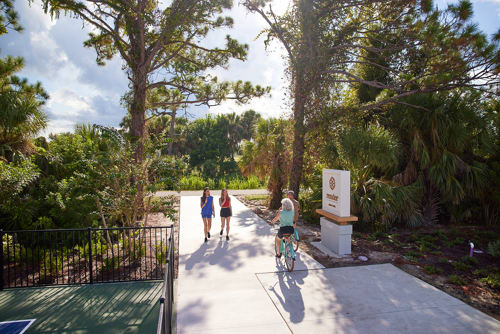 entrance to Legacy Trail with biker riders